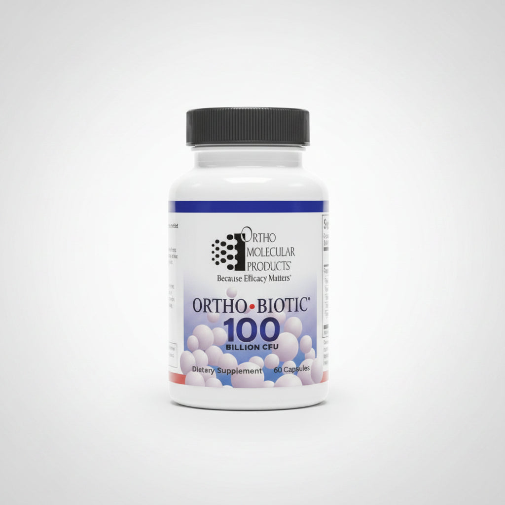 A bottle of Ortho-Ncicular Products Ortho-Biotic 100 Billion Cols supplement resting on a laptop keyboard in a home office setting.